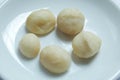 Top view of macadamia nuts in bowl on white background. Royalty Free Stock Photo