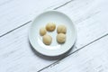Top view of macadamia nuts in bowl on wooden background. Royalty Free Stock Photo