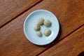 Top view of macadamia nuts in bowl on wooden background. Royalty Free Stock Photo