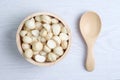 Top view macadamia nuts and shell in wooden bowl