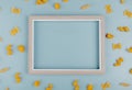 top view of macaronis as farfalle fusilli penne pipe-rigate around frame on blue background with copy space