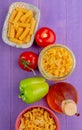 top view of macaronis as penne pipe-rigate and others with tomato pepper butter on purple background