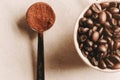 Top view, macro shot of coffee cup full of coffee beans and coffee ground in tiny spoon Royalty Free Stock Photo