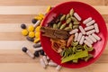 Top view macro shot of herbal pills and tablets arranged with spices on a red stone. Unani medicines concept Royalty Free Stock Photo