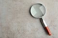 Top view of magnifier glass on grey stone background, space for text. Find keywords concept Royalty Free Stock Photo