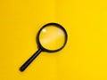 Top view magnifying glass isolated on yellow background.