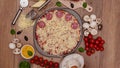 Top view of making a pizza with ingredients appearing on the rotating setting