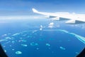 Top view of Maldive islands from airplane window with airplane`s wing