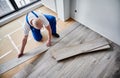 Man installing laminate wood flooring in apartment under renovation. Royalty Free Stock Photo
