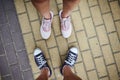 Top view of male and female legs in sneakers, standing on pavement. Selective focus. Close-up. Copy advertising space Royalty Free Stock Photo