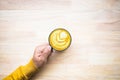 Top view of male hand holding cup of coffee on wood tabl Royalty Free Stock Photo