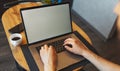 Top view of male hands typing on computer keyboard; man working on laptop; smartphone and coffee cup on wooden table. Royalty Free Stock Photo