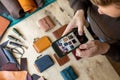 Top view male tanner hands taking photo of exclusive leatherwork accessories. Leather workshop