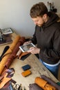 Top view male tanner use tablet at leather workshop. Craftsman creating online advertising promotion