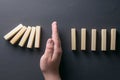 Top view man hand stopping falling dominos in a business crisis management conceptual image Royalty Free Stock Photo