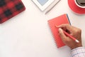 Top view of man hand writing on red notepad with pencil Royalty Free Stock Photo