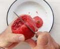 Top view of man hands cutting pomegranate with a knife Royalty Free Stock Photo