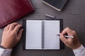 Top view of man hands writing on empty notebook with pen in office. Royalty Free Stock Photo