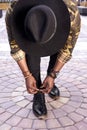 Top view on man in a hat tying his shoelaces Royalty Free Stock Photo