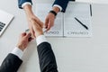 View of man holding envelope with money near business partner and laptop Royalty Free Stock Photo