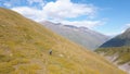 Top view of man riding horse in mountains. Clip. Mountain landscape with man on horse among yellow slopes on background Royalty Free Stock Photo