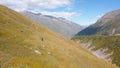 Top view of man riding horse in mountains. Clip. Mountain landscape with man on horse among yellow slopes on background Royalty Free Stock Photo