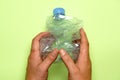 top view of man's hands grasping a squeezed plastic bottle. plastic recycling concept. flat lay flat design