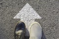 Top view of man wearing black and white shoes choosing a way marked with white arrows. Chooses the right path concept Royalty Free Stock Photo