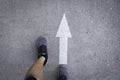 Top view of man wearing shoes choosing a way marked with white arrows. Chooses the right path concept Royalty Free Stock Photo