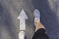 Top view of man wearing white shoes choosing a way marked with white arrows. Chooses the right path concept Royalty Free Stock Photo