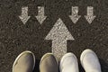 Top view of man wearing white shoes choosing a way marked with white arrows. Chooses the right path concept Royalty Free Stock Photo