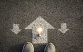 Top view of man wearing white shoes choosing a way marked with white arrows and light bulb. Chooses the right path concept Royalty Free Stock Photo