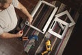 Top view of man working in a carpentry shop. Assembling a white aluminum window. Horizontal image