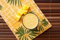 top view of a mango pineapple smoothie on a bamboo mat