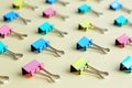 Top view of many multicolor binders clips on pastel beige background. Royalty Free Stock Photo