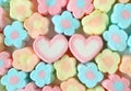 Top View of Many Pastel Blue and Yellow Flower Shaped with A Pair of Pink and White Heart Shaped Marshmallow Candies