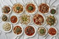 Top view of many plates on dinner dishes from different dishes covered in sauce on white background Royalty Free Stock Photo