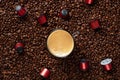 Top view of many roasted coffee beans and glass cup with fresh espresso coffee. Capsules for coffee machines Royalty Free Stock Photo