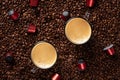 Top view of many roasted coffee beans and two glass cups with fresh espresso coffee. Capsules for coffee machines Royalty Free Stock Photo
