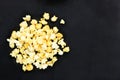 Top view of many salted popcorn mix with cheese popcorn pile on black table background, have copy space