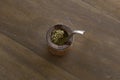 Top view of Mate caffeine-rich infused drink in a palo santo wood cup with a metal straw