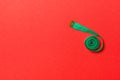 Top view of measure tape curtailed into a spiral with copy space. Concept of sewing accessory or healthy diet on red background