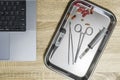 Top view of medical instruments and laptop. Syringe, clamp, thermometer on a clay