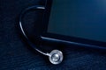 Top of view of medical stethoscope near modern digital tablet pc in laboratory on wood table Royalty Free Stock Photo