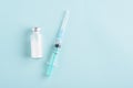 Top view medical syringe, ampoule on blue background, vaccination, inoculation concept