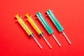 Top view of medical syringes with needles at red background with copy space. Injection treatment concept