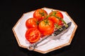 Plate of, four vine ripe tomatoes and one halved Royalty Free Stock Photo