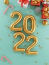 Top view of Merry Christmas and happy new year realistic design of gold 2022 year and close red gift boxes with decorative golden Royalty Free Stock Photo