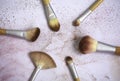 Top view of messy used eco-friendly makeup brushes with bamboo handles in a circle on white and pink background with traces of Royalty Free Stock Photo