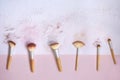 Top view of messy used eco-friendly makeup brushes with bamboo handles on white and pink background with traces of cosmetic makeup Royalty Free Stock Photo